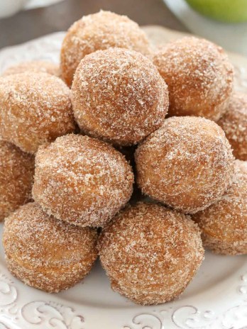 A white plate piled high with apple cider donut holes.