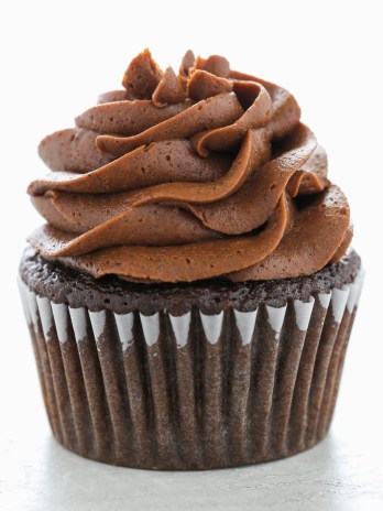 A single chocolate cupcake topped with a swirl of chocolate buttercream frosting.