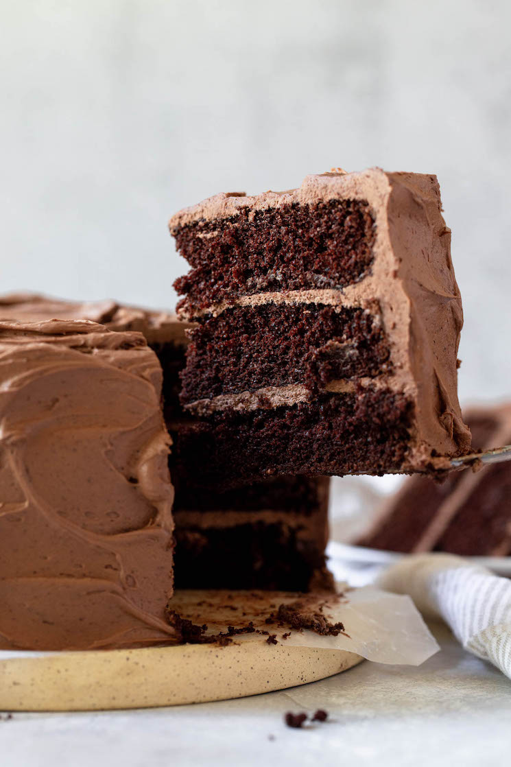 A single piece of a layered chocolate cake being removed showing the different layers. 