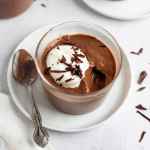 A glass filled with chocolate pudding.