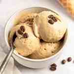 A bowl filled with three scoops of coffee ice cream.