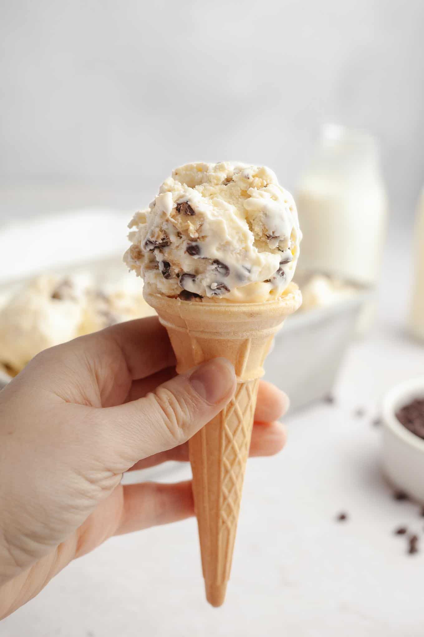 An ice cream cone being held aloft. 