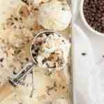 An overhead view of cookie dough ice cream with a scoop of ice cream resting on top.
