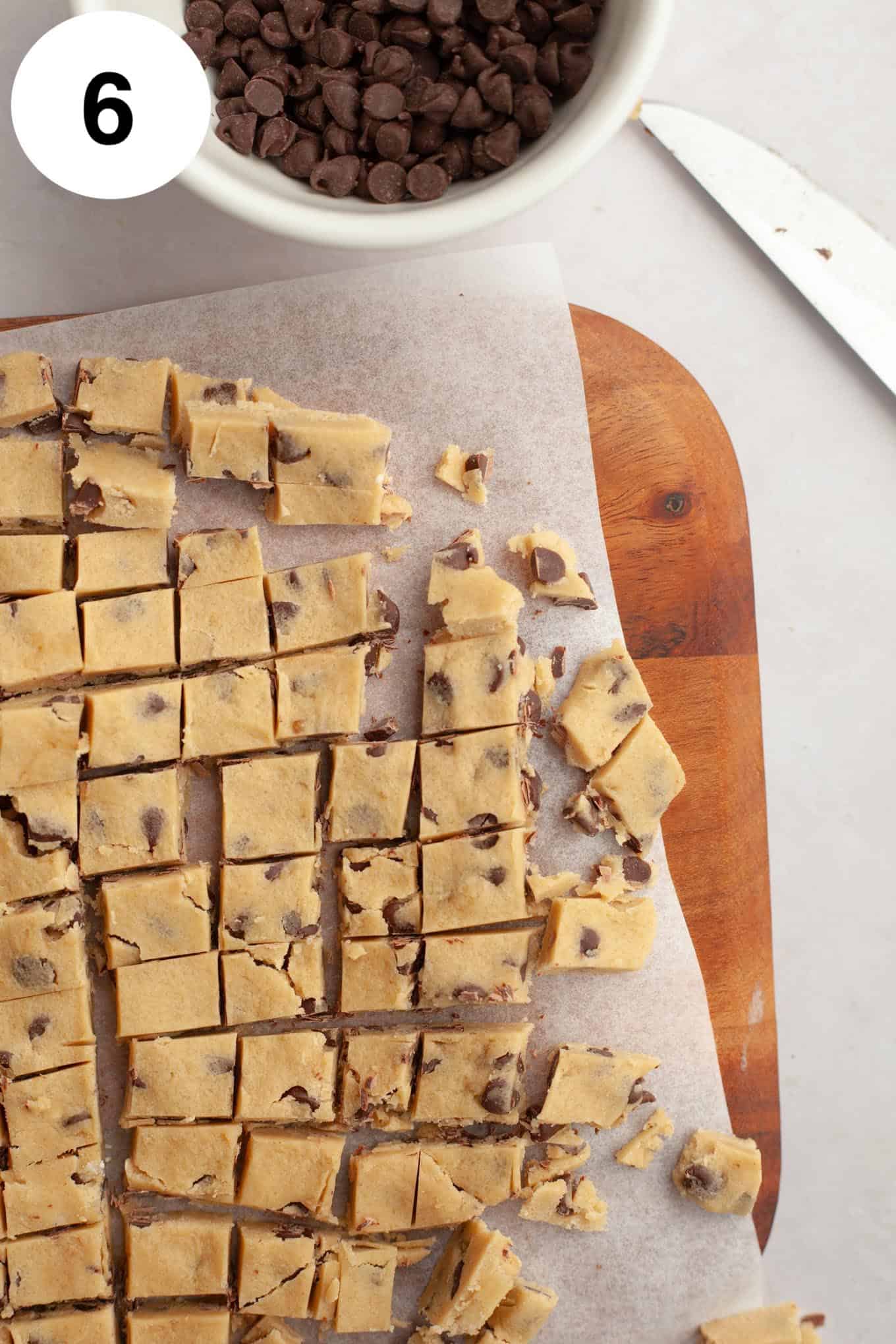 An overhead view of edible chocolate chip cookie dough cut into bite-sized pieces. 