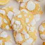 Several lemon crinkle cookies on a piece of parchment paper.
