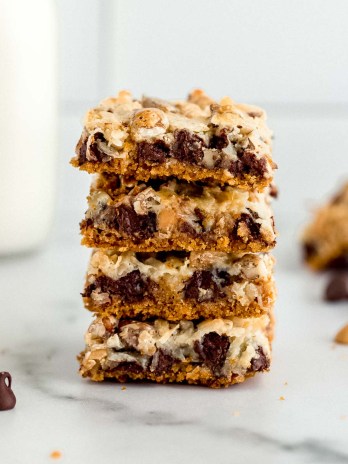 A stack of magic cookie bars sitting on a marble surface.