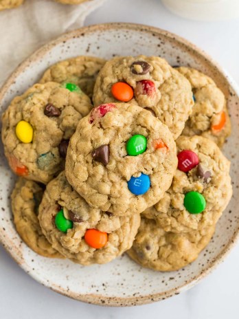 A stack of monster cookies on a speckled plate.