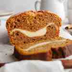 A loaf of pumpkin cream cheese bread that's been sliced.