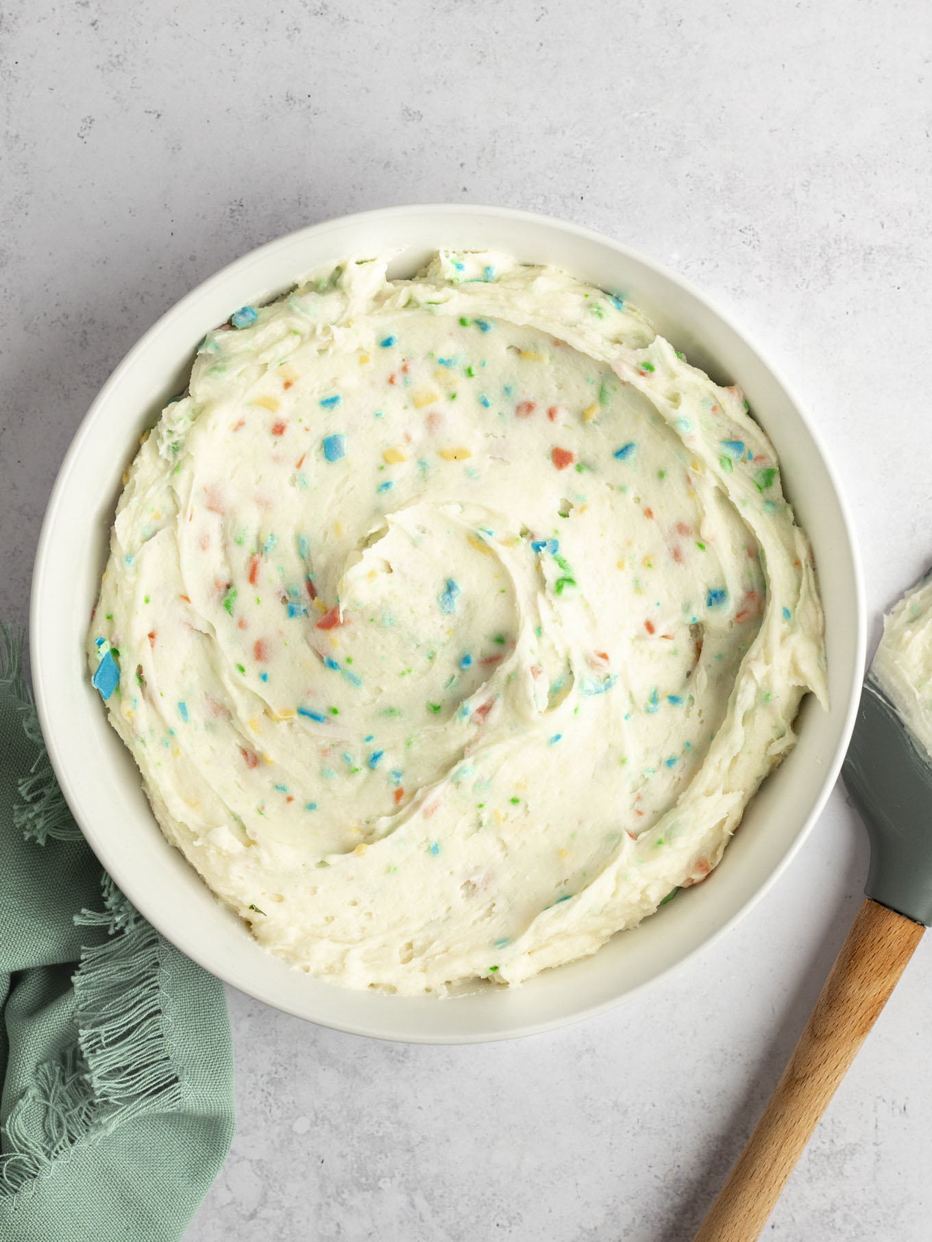 An overhead view of a bowl of homemade rainbow chip frosting. 