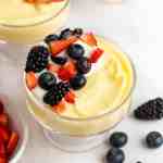 A bowl of vanilla pudding topped with fresh berries.